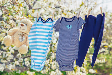 Baby clothes and accessories weigh on the rope after washing in the open air. Selective focus.