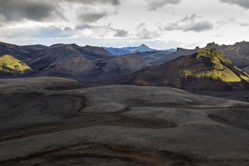 Dramatic iceland landscape with a green hill and black lava looks like a moon. Serenity of Iceland.