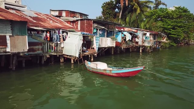 Close-up details poor houses balconies slums in green sea water Asia hopeless ghetto rusty. Ship authentic boat real life dirt. Tropical exotic cityscape Vietnam Asia. Authentic culture style. Drone