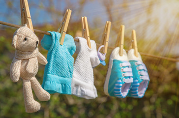 Baby clothes and accessories weigh on the rope after washing in the open air. Selective focus.