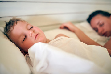 Obraz na płótnie Canvas Toddler boy sleeping on pillow with mother