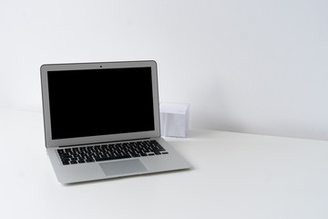 Open laptop and note cube on the desk with white background