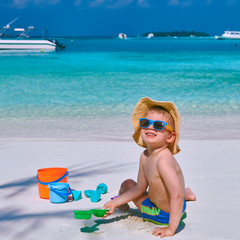 Three year old toddler playing on beach