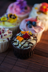 Beautiful and delicious cupcakes on the table. A set of delicious sweet desserts