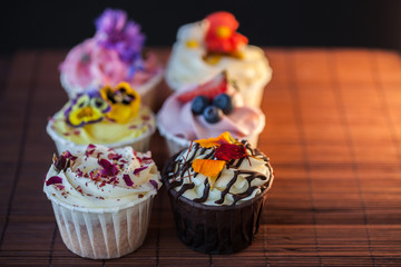 Beautiful and delicious cupcakes on the table. A set of delicious sweet desserts