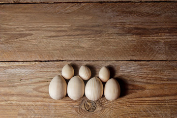 decorative wooden eggs laid out in an unusual way on a rustic table. symbolic holiday composition for gift card. copy space. close up top view