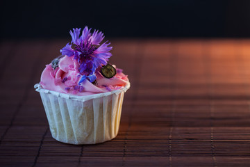 Beautiful and delicious cupcakes on the table. Sweet dessert with berries and cream.