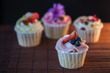 Beautiful and delicious cupcakes on the table. A set of delicious sweet desserts