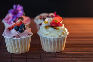 Beautiful and delicious cupcakes on the table. A set of delicious sweet desserts