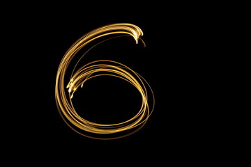 Long exposure, light painting photography.  Single number in a vibrant neon metallic yellow gold colour against a black background