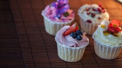 Beautiful and delicious cupcakes on the table. A set of delicious sweet desserts