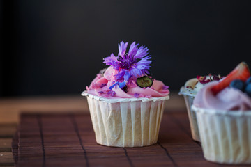 Beautiful and delicious cupcakes on the table. A set of delicious sweet desserts