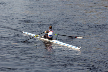Woman Single sculls rower. girl engaged in rowing on the river