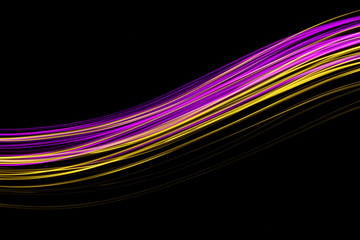 Long exposure, light painting photography.  Vibrant neon streaks of colour against a black background