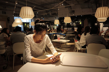 Woman typing write message on smart phone in a modern cafe.