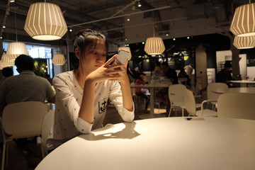 Woman typing write message on smart phone in a modern cafe.