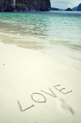 Love and romance. The inscription on the sand. Holidays by the sea.