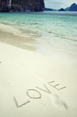 Love and romance. The inscription on the sand. Holidays by the sea.