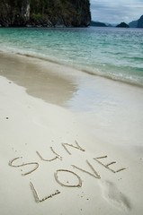 Love and romance. The inscription on the sand. Holidays by the sea.