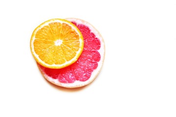 Fototapeta na wymiar a white background and a round orange and pink grafefruit cut, minimalism, close-up, selective focus, save space