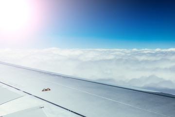 Fototapeta na wymiar Airplane wing through the aircraft window. Greenhouse effect, global warming. Sunshine.
