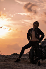 Fototapeta na wymiar girl at sunset near the motorbike