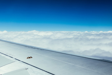 Fototapeta na wymiar Airplane wing through the aircraft window. Greenhouse effect, global warming.
