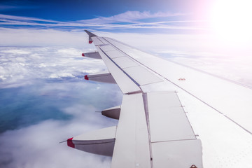 Airplane wing through the aircraft window. Greenhouse effect, global warming. Sunshine.