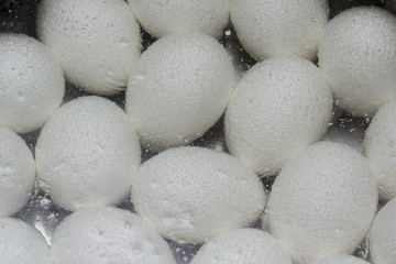 White eggs at the bottom of the pot in boiling water. Concept - healthy food