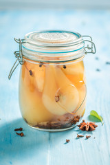 Homemade and sweet pickled pears on blue table