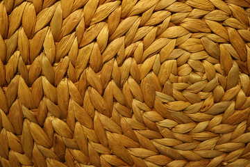 Texture and pattern of a golden brown color woven water hyacinth place mat