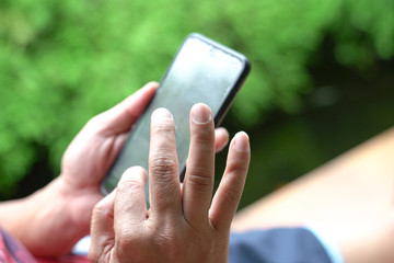 Closeup view of man's hands on mobile phone