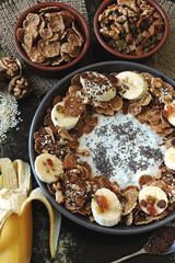 Healthy breakfast bowl with yogurt and chia, cereal, raisins, banana, walnut and seeds. Superfoods Energy food. Keto diet.