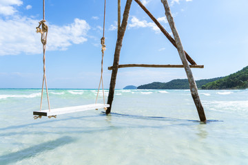 A beautiful, tranquil and luxurious sea swing standing in a crystal clear blue sea with green hills behind, White sand Beach in Vietnam , Pho Quoc