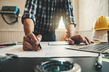 Engineer man working in the office, Drawing the construction project.