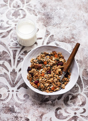 Crispy granola muesli with dried fruits, nuts and seeds and a jar of yogurt for a healthy breakfast