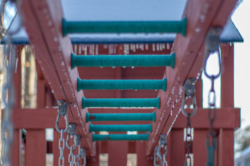 monkey bars on a swingset frozen in winter