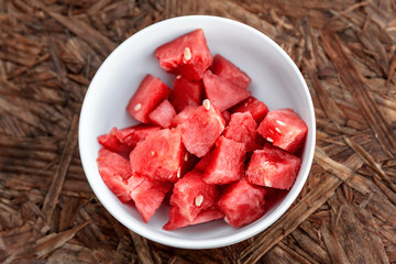 Organic watermelon in a white bowl ready to eat on wooden background © photobyevgeniya