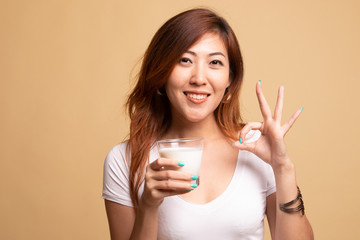 Healthy Asian woman drinking a glass of milk show OK sign.