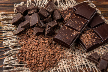 Chocolate bar and cocoa on dark wooden background.