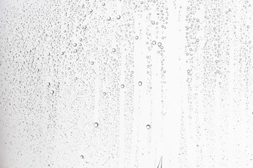 white isolated background water drops on the glass / wet window glass with splashes and drops of...
