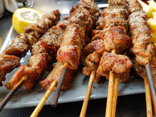 souvlaki greek etnic food meat  roasted in a plate whith lemon and potatoes friend