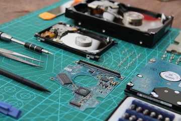 the hard drive is disassembled on the table with tools