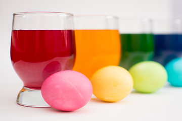 Getting ready for Easter. Coloring eggs with color dyes and glass goblets.