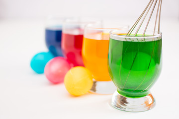 Getting ready for Easter. Coloring eggs with color dyes and glass goblets.