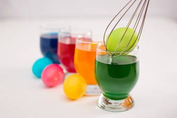 Getting ready for Easter. Coloring eggs with color dyes and glass goblets.
