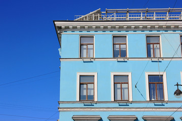 Colorful building facade architecture of minimalist house with windows in row on empty blue sky background