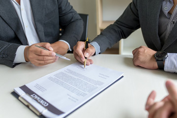 Business people, signing a contract, meeting together at a meeting.
