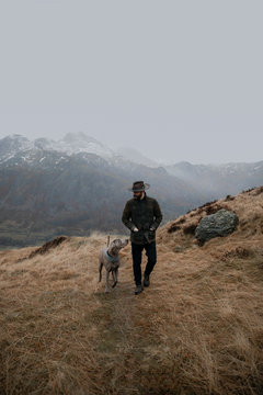 man walking with dog in the mountains