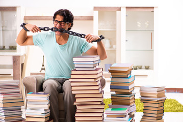 Male student with many books at home 